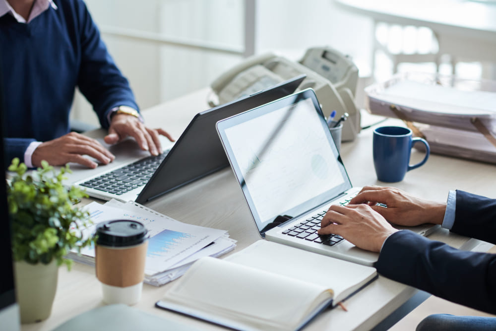 Arbeitsplatz mit Laptop, Unterlagen und Diagrammen